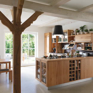 Offene, Mittelgroße Landhausstil Küche in L-Form mit flächenbündigen Schrankfronten, hellbraunen Holzschränken, Arbeitsplatte aus Holz, Küchenrückwand in Schwarz, Vinylboden, Halbinsel und beigem Boden in Hannover