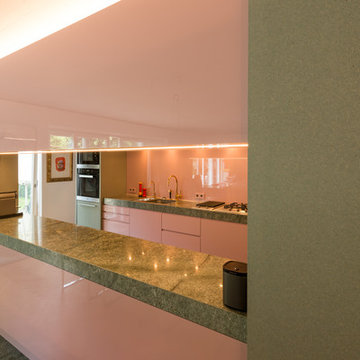 Zweizeilige Küche mit Akzenten in Pastell und massiver Granit-Arbeitsplatte