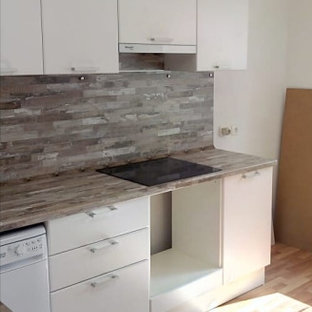 Mid-sized scandinavian l-shaped separate kitchen in Yekaterinburg with a double-bowl sink, flat-panel cabinets, white cabinets, laminate benchtops, multi-coloured splashback, black appliances and pink benchtop.
