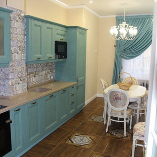 Diseño de cocina lineal, mediterránea, de tamaño medio, cerrada, sin isla, con fregadero bajoencimera, armarios con paneles con relieve, puertas de armario turquesas, encimera de madera, salpicadero multicolor, salpicadero de azulejos de cerámica, electrodomésticos negros, suelo de baldosas de porcelana, suelo multicolor y encimeras naranjas