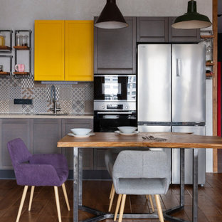 Immagine di una cucina industriale con lavello sottopiano, ante in stile shaker, ante in legno bruno, paraspruzzi grigio, elettrodomestici in acciaio inossidabile, parquet scuro, pavimento marrone e top beige
