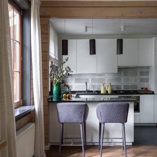 Modern inredning av ett mellanstort kök, med en nedsänkt diskho, släta luckor, vita skåp, granitbänkskiva, flerfärgad stänkskydd, stänkskydd i keramik, rostfria vitvaror, en halv köksö, svart golv och mellanmörkt trägolv