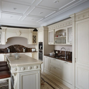 Traditional kitchen in Moscow with a double-bowl sink, raised-panel cabinets, beige cabinets, brown splashback, stainless steel appliances and with island.