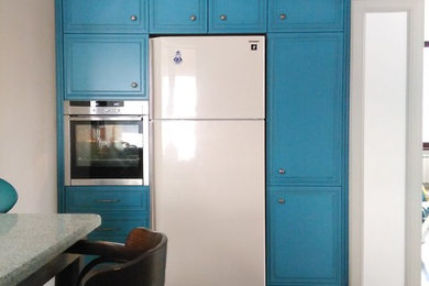 Foto på ett avskilt, mellanstort lantligt l-kök, med luckor med upphöjd panel, blå skåp och granitbänkskiva