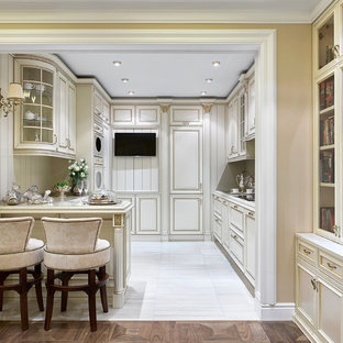 Photo of a traditional u-shaped open plan kitchen in Moscow with an integrated sink, white cabinets, quartz benchtops, beige splashback, timber splashback, white appliances, porcelain floors, a peninsula, white floor and recessed-panel cabinets.