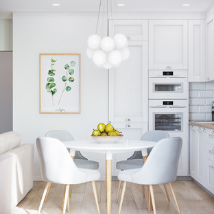 Inspiration for a small scandinavian l-shaped open plan kitchen in Other with beaded inset cabinets, white cabinets, a drop-in sink, wood benchtops, white splashback, ceramic splashback, white appliances, laminate floors, beige floor and beige benchtop.