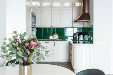 Inspiration for a small contemporary u-shaped kitchen/diner in Moscow with white cabinets, engineered stone countertops, green splashback, laminate floors, beige floors, shaker cabinets, integrated appliances, no island and white worktops.