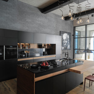 Design ideas for a mid-sized contemporary galley kitchen in Saint Petersburg with black appliances, with island, an undermount sink, flat-panel cabinets, white cabinets, black splashback, medium hardwood floors, brown floor and black benchtop.