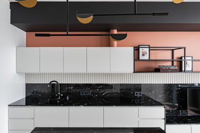 Inspiration för ett litet skandinaviskt svart linjärt svart kök och matrum, med en undermonterad diskho, släta luckor, vita skåp, granitbänkskiva, svart stänkskydd, svarta vitvaror, mellanmörkt trägolv, en köksö och grått golv
