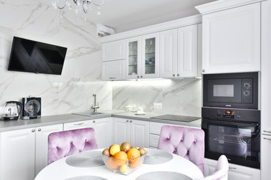 Inredning av ett klassiskt litet grå grått kök, med en nedsänkt diskho, luckor med upphöjd panel, vita skåp, grått stänkskydd, stänkskydd i porslinskakel och integrerade vitvaror