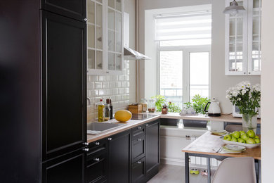Modern inredning av ett litet linjärt kök och matrum, med en undermonterad diskho, svarta skåp, vitt stänkskydd, stänkskydd i keramik, svarta vitvaror och mellanmörkt trägolv