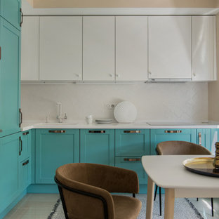 Design ideas for a mid-sized eclectic l-shaped eat-in kitchen in Moscow with an integrated sink, raised-panel cabinets, turquoise cabinets, solid surface benchtops, white splashback, ceramic splashback, stainless steel appliances, porcelain floors, no island, beige floor and white benchtop.