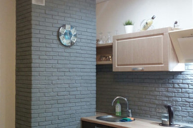 Imagen de cocina lineal contemporánea de tamaño medio cerrada con armarios con paneles lisos, puertas de armario grises, salpicadero verde y encimeras beige