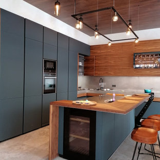 This is an example of a large contemporary l-shaped kitchen in Moscow with a single-bowl sink, flat-panel cabinets, black cabinets, wood benchtops, grey splashback, panelled appliances, porcelain floors, with island, grey floor and brown benchtop.