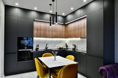 Example of a mid-sized trendy l-shaped gray floor eat-in kitchen design in Saint Petersburg with an integrated sink, flat-panel cabinets, black cabinets, paneled appliances, no island and black countertops