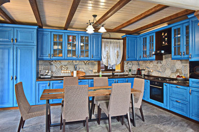 This is an example of a medium sized rustic l-shaped kitchen/diner in Moscow with an integrated sink, raised-panel cabinets, blue cabinets, composite countertops, multi-coloured splashback, porcelain splashback, black appliances, porcelain flooring, no island, grey floors and brown worktops.