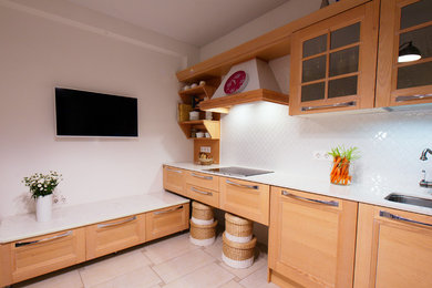 Пример оригинального дизайна: прямая кухня среднего размера в стиле кантри с обеденным столом, светлыми деревянными фасадами, столешницей из кварцевого агломерата и белой столешницей