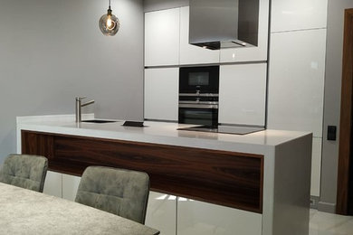 This is an example of a medium sized contemporary single-wall kitchen/diner in Other with a submerged sink, composite countertops, ceramic flooring, an island and white worktops.