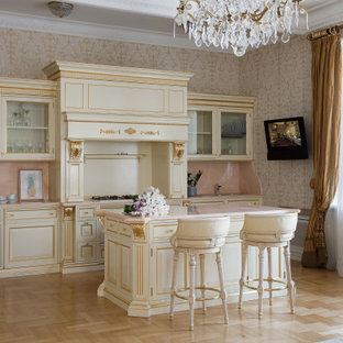 Inspiration för ett vintage rosa rosa kök, med luckor med upphöjd panel, vita skåp, rosa stänkskydd, stänkskydd i sten, ljust trägolv, en köksö och beiget golv