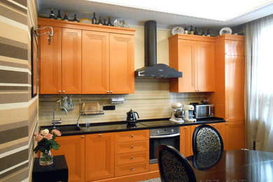 Пример оригинального дизайна: кухня с оранжевыми фасадами и обоями на стенах