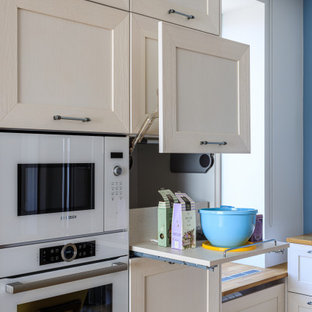 Inspiration for a large scandinavian galley eat-in kitchen in Moscow with a drop-in sink, recessed-panel cabinets, white cabinets, wood benchtops, blue splashback, white appliances, medium hardwood floors, no island, brown floor and beige benchtop.