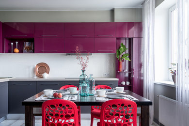 Стильный дизайн: угловая кухня-гостиная в современном стиле с плоскими фасадами, фиолетовыми фасадами и белым фартуком без острова - последний тренд