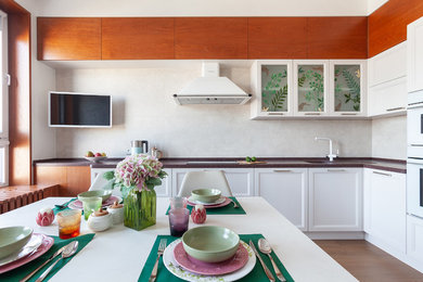 Example of a mid-sized trendy l-shaped porcelain tile enclosed kitchen design in Yekaterinburg with an integrated sink, recessed-panel cabinets and porcelain backsplash