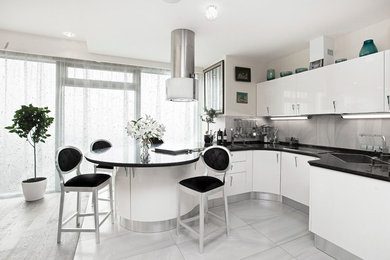 Свежая идея для дизайна: угловая кухня в современном стиле с накладной мойкой, плоскими фасадами, белыми фасадами, серым фартуком и полуостровом - отличное фото интерьера