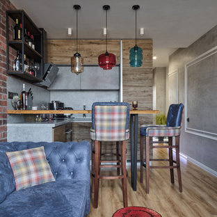 Small industrial u-shaped open plan kitchen in Moscow with an undermount sink, flat-panel cabinets, medium wood cabinets, concrete benchtops, grey splashback, black appliances, laminate floors, no island, beige floor and grey benchtop.