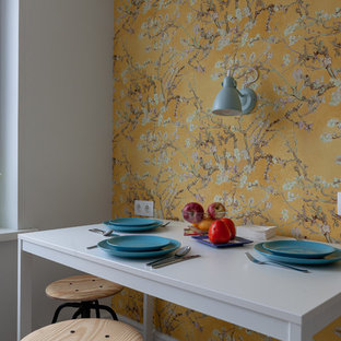 Minimalistisk inredning av ett avskilt, litet svart linjärt svart kök, med en undermonterad diskho, skåp i shakerstil, vita skåp, laminatbänkskiva, vitt stänkskydd, stänkskydd i keramik, klinkergolv i porslin och beiget golv