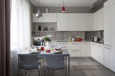 Contemporary grey and white l-shaped open plan kitchen in Moscow with flat-panel cabinets, light wood cabinets, grey splashback, stainless steel appliances, no island and a built-in sink.