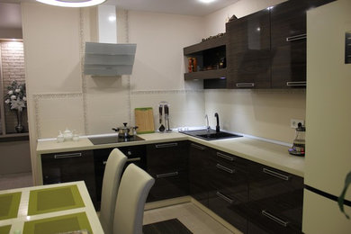 This is an example of a medium sized contemporary l-shaped enclosed kitchen in Other with flat-panel cabinets, dark wood cabinets, beige splashback, ceramic splashback, porcelain flooring and multi-coloured floors.