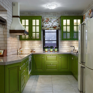 Ispirazione per una cucina country di medie dimensioni con ante con bugna sagomata, ante verdi, paraspruzzi beige, elettrodomestici bianchi, nessuna isola, lavello sottopiano, top in superficie solida, paraspruzzi con piastrelle in ceramica, pavimento con piastrelle in ceramica, pavimento beige e top grigio