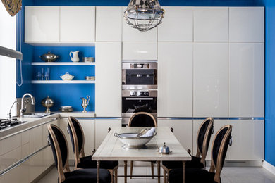 Imagen de cocinas en L contemporánea grande con armarios con paneles lisos, puertas de armario blancas y encimeras blancas