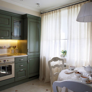 Small shabby-chic style l-shaped separate kitchen in Moscow with beige floor, an undermount sink, recessed-panel cabinets, green cabinets, solid surface benchtops, white splashback, ceramic splashback, white appliances, porcelain floors and white benchtop.