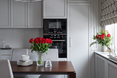 Идея дизайна: кухня в стиле неоклассика (современная классика) с обеденным столом и серыми фасадами