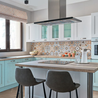 Foto di una cucina contemporanea chiusa con lavello da incasso, ante con riquadro incassato, ante turchesi, paraspruzzi multicolore, elettrodomestici colorati, pavimento marrone e top beige