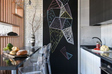 Стильный дизайн: маленькая кухня в современном стиле с столешницей из кварцевого агломерата, серым фартуком, фартуком из стекла, черной техникой и черной столешницей - последний тренд