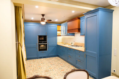 На фото: угловая кухня-гостиная среднего размера в стиле неоклассика (современная классика) с фасадами с утопленной филенкой и синими фасадами без острова с