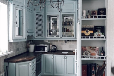 モスクワにある高級な中くらいなトラディショナルスタイルのおしゃれなキッチン (ガラス扉のキャビネット、グレーのキャビネット、ベージュキッチンパネル、シルバーの調理設備、アイランドなし) の写真