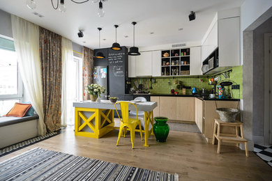 Источник вдохновения для домашнего уюта: кухня в современном стиле с плоскими фасадами, белыми фасадами, зеленым фартуком, фартуком из плитки кабанчик, черной техникой, островом и коричневым полом
