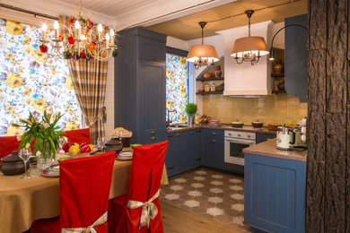 Источник вдохновения для домашнего уюта: п-образная кухня среднего размера в стиле кантри с обеденным столом, фасадами с утопленной филенкой, синими фасадами и столешницей из акрилового камня
