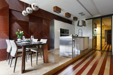 Идея дизайна: параллельная кухня в современном стиле с плоскими фасадами, белыми фасадами, техникой из нержавеющей стали, островом и обеденным столом