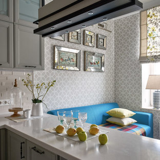 Design ideas for a small transitional u-shaped open plan kitchen in Moscow with a drop-in sink, recessed-panel cabinets, grey cabinets, quartz benchtops, beige splashback, ceramic splashback, black appliances, medium hardwood floors, a peninsula and brown floor.
