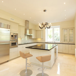 Mid-sized transitional l-shaped separate kitchen in Moscow with a double-bowl sink, louvered cabinets, beige cabinets, quartzite benchtops, beige splashback, porcelain splashback, stainless steel appliances, porcelain floors, with island, beige floor and black benchtop.