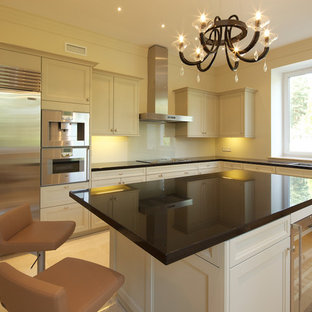 Design ideas for a mid-sized transitional l-shaped separate kitchen in Moscow with a double-bowl sink, louvered cabinets, beige cabinets, quartzite benchtops, beige splashback, porcelain splashback, stainless steel appliances, porcelain floors, with island, beige floor and black benchtop.