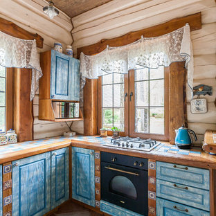 Modelo de cocina en U, romántica, con fregadero encastrado, armarios con paneles con relieve, puertas de armario azules, encimera de azulejos y península