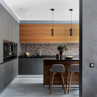 Design ideas for a mid-sized contemporary l-shaped open plan kitchen in Moscow with an integrated sink, flat-panel cabinets, grey cabinets, granite benchtops, porcelain splashback, black appliances, porcelain floors, with island, grey floor and black benchtop.