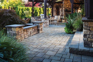 Mid-sized elegant backyard stone patio photo in Seattle