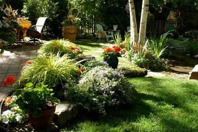 Photo of a mid-sized eclectic shade backyard brick landscaping in Boise for summer.
